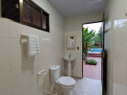 y baño con aseo y lavamanos. en Casa de huespedes con piscina privada en Villa Tunari