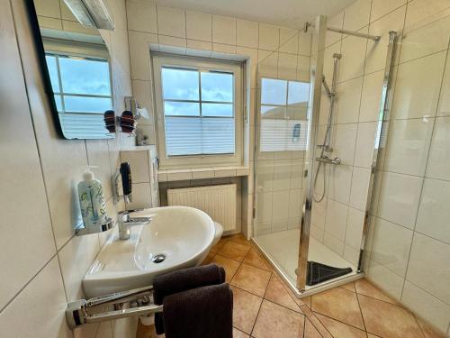 a bathroom with a sink and a shower at Schnütgenhof Appartements in Attendorn