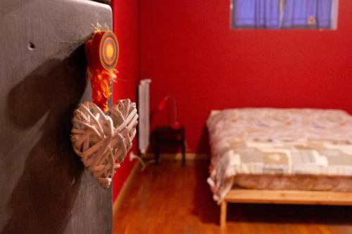 um quarto vermelho com uma cama e uma parede com uma corda em Dream10 em Parabiago