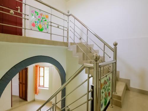 una escalera en una casa con un arco en OYO Flagship Aiswarya Residency, en Wayanad