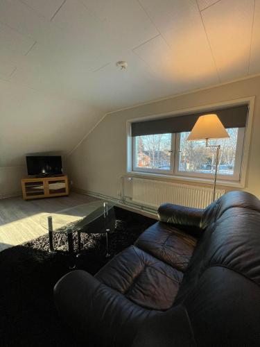 un soggiorno con divano e una grande finestra di Serenity Cottage a Närpiö