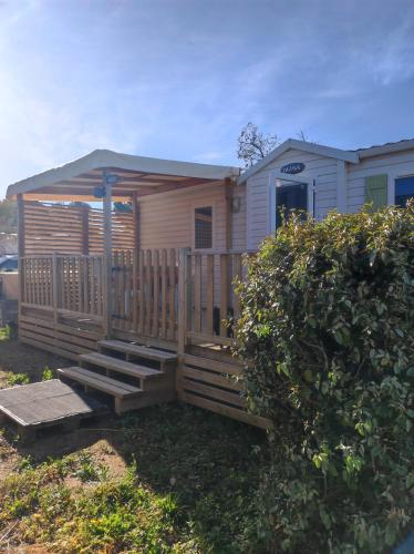 a mobile home with a porch and a deck at MOBIL HOME climatisé camping NOVELA PORT LA NOUVELLE in Port-la-Nouvelle