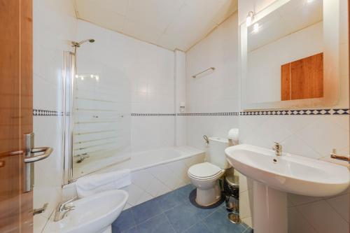 bagno bianco con lavandino e servizi igienici di SevillaHome-Apartamento complejo piscina parking a Siviglia
