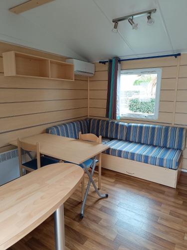 a room with a couch and a table and a bench at MOBIL HOME LUCKY climatisé camping NOVELA PORT LA NOUVELLE in Port-la-Nouvelle