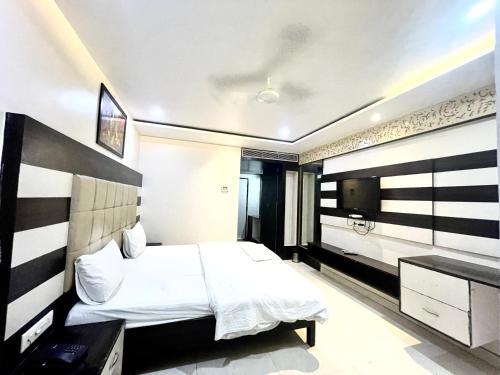 une chambre d'hôtel avec un lit et une télévision dans l'établissement HOTEL P PALACE ! VARANASI fully-Air-Conditioned-hotel lift-and-Parking-availability, near Kashi Vishwanath Temple, and Ganga ghat, à Varanasi
