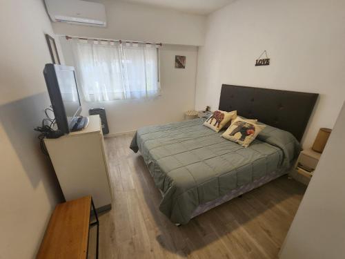 a bedroom with a bed and a flat screen tv at Casita a metros del Parque Independencia con garaje incluido in Rosario