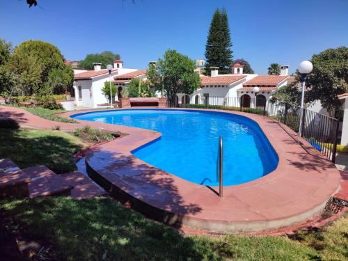 a swimming pool in a yard with a house at Villas Tequisquipan in Tequisquiapan
