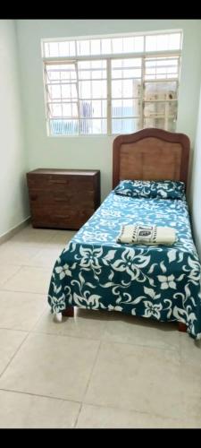 um quarto com uma cama com um cobertor azul e branco em Casa Inteira e Grande 600MB de Internet. Ótima Loc em Uberlândia