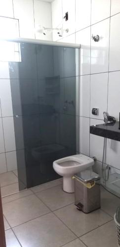 a bathroom with a toilet and a glass shower at Casa Inteira e Grande 600MB de Internet. Ótima Loc in Uberlândia