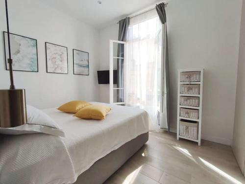 une chambre blanche avec un lit et une fenêtre dans l'établissement LaCamiHome, à Menton