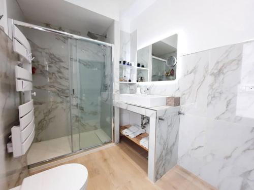 une salle de bain blanche avec une douche et un lavabo dans l'établissement LaCamiHome, à Menton