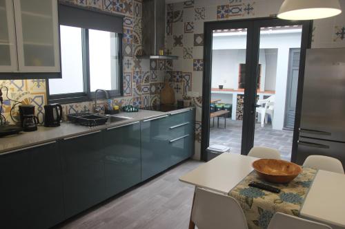 a kitchen with blue cabinets and a table with a bowl on it at Casa D'Alegria in Ponta Delgada