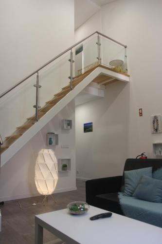 a living room with a blue couch and a staircase at Casa D'Alegria in Ponta Delgada