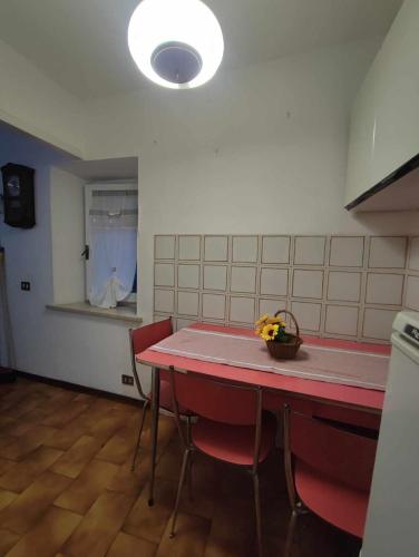 a kitchen with a red table and red chairs at Casa Innocenti Daniele in Volterra
