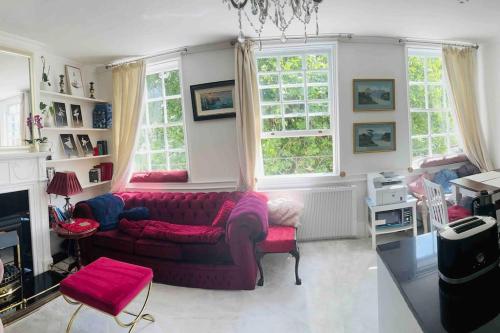 a living room with a couch and two windows at Flat in the heart of Bath with stunning views in Bath