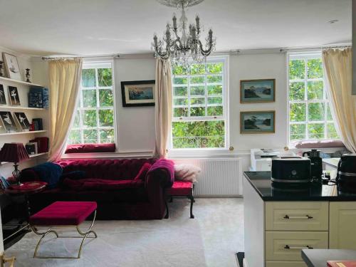 a living room with a couch and two windows at Flat in the heart of Bath with stunning views in Bath