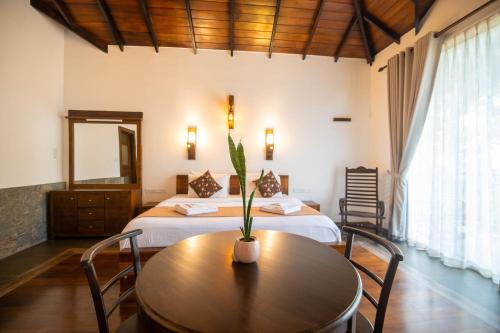 a bedroom with a table and a bed with a mirror at Grand Argyle Resort in Hatton