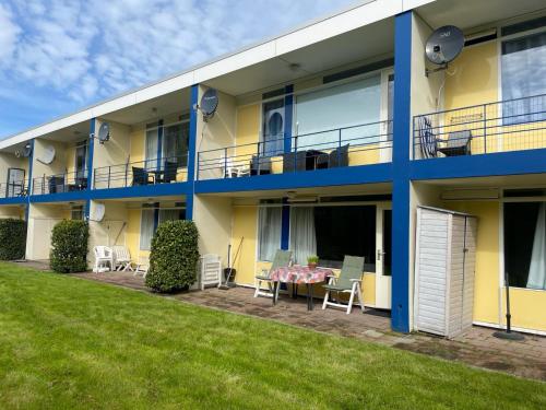an apartment building with a table and chairs on the patio at Vakantiehuisje Martina 17 in Vlissingen
