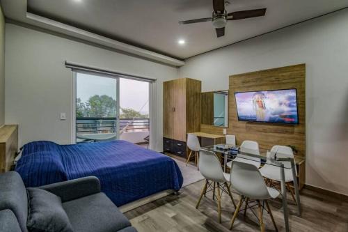 1 dormitorio con 1 cama, mesa y sillas en Sierra Apartments Estudios en Oaxtepec, en Oaxtepec