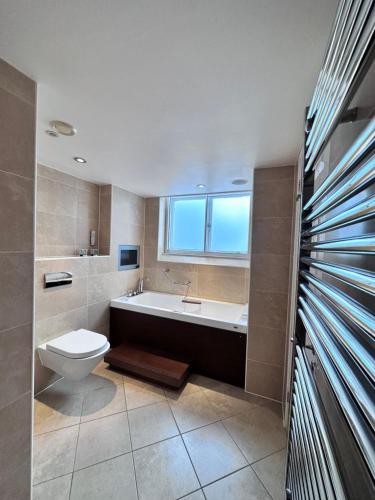 a bathroom with a tub and a toilet and a sink at Cathedral Quarter Hotel - Derby in Derby