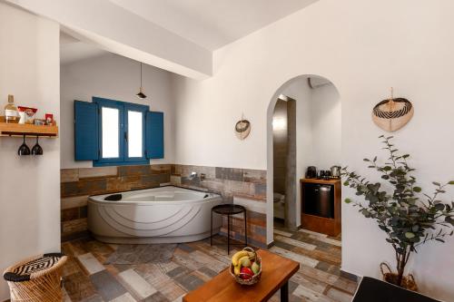 a large bathroom with a tub and a table at San Constantino Boutique Villa in Fira