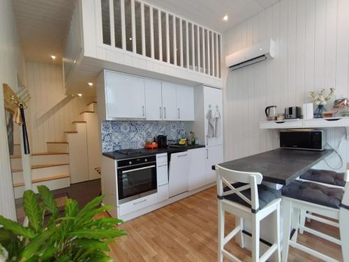 una cocina con armarios blancos, una mesa y una escalera en Bålsta Studio Houses en Bålsta