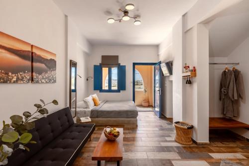 a living room with a couch and a bed at San Constantino Boutique Villa in Fira