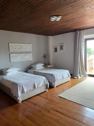 a bedroom with two beds and a wooden floor at A Flor Da Rosa in Crato