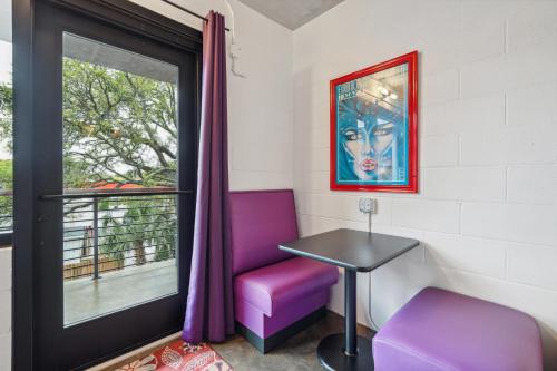 a room with a purple chair and a table and a window at Boutique Vera Hotel in the Heart of Folly Beach in Folly Beach