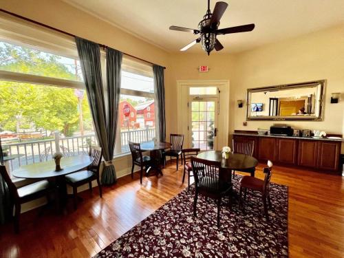 a living room with tables and chairs and a ceiling fan at Hotel Belvidere in Belvidere