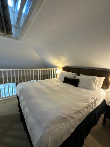 sypialnia z dużym łóżkiem z białą pościelą i poduszkami w obiekcie Cathedral Quarter Hotel - Derby w mieście Derby