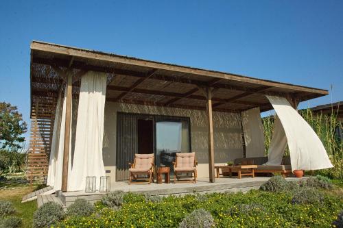 a pavilion with two chairs and a table at Zaya Çeşme Hotel & Beach in Çeşme