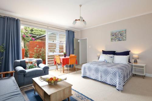 ein Schlafzimmer mit einem Bett und ein Wohnzimmer in der Unterkunft FOUR C's Guest Units in Craighall Park in Johannesburg