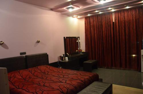 a bedroom with a red bed and a red curtain at Happy Villa in Zovuni