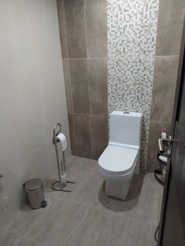 a bathroom with a toilet and a trash can at Happy Villa in Zovuni