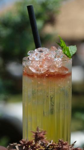 a drink with a green liquid and a black straw at Zaya Çeşme Hotel & Beach in Çeşme