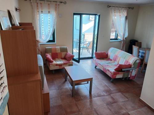 a living room with two couches and a table at Apartman sa bazenom in Radovići