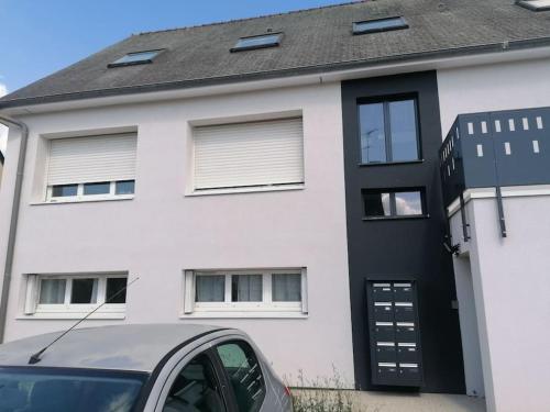 une maison blanche avec une porte noire et une voiture dans l'établissement Le Cesson - Cosy Duo, à Cesson-Sévigné