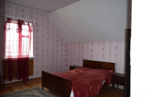 1 dormitorio con 1 cama con manta roja y ventana en Вила Eco Garden, en Gyumri