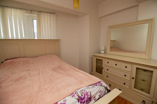 um quarto com uma cama e uma cómoda com um espelho em APARTMENTS ANI em Ulcinj