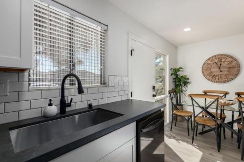 a kitchen with a sink and a clock on the wall at Modern Townhouse-Walk 2 OldTown-4 Heated Pools in Scottsdale