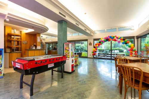 a room with a pool table in the middle of a restaurant at Hotel Columbia in Marina Romea