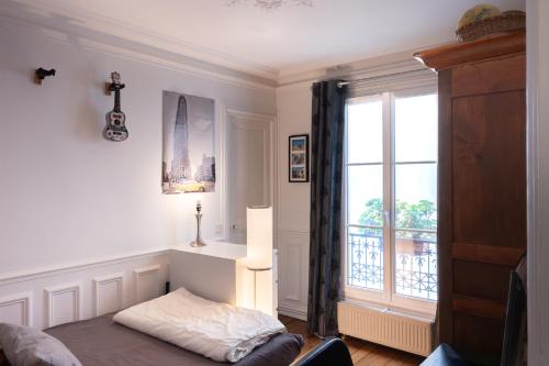 een kamer met een raam en een tafel met een lamp bij Luxueux et spacieux 100m², Faidherbe, 11th ard in Parijs