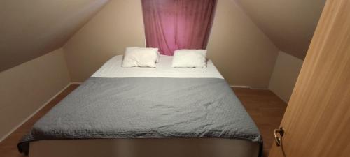 um pequeno quarto com uma cama com duas almofadas em Semesterhus i Yngsjö em Yngsjö