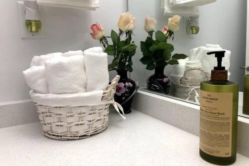 a basket of towels on a counter next to a mirror at Gorgeous 2 Bedrooms Suite Private entrane with patio-Free Parking in Maple Ridge District Municipality