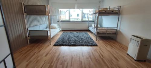 Zimmer mit 2 Etagenbetten und einem Teppich in der Unterkunft Semesterhus i Yngsjö in Yngsjö