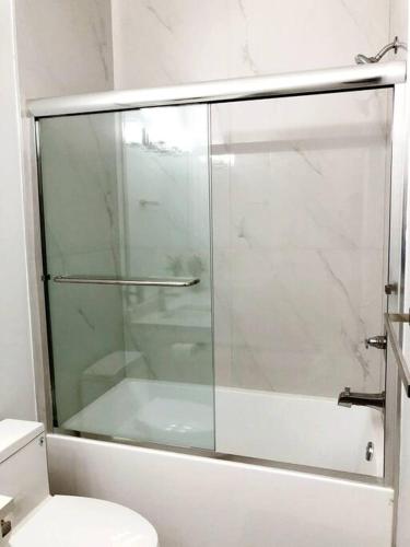 a glass shower in a bathroom with a toilet at Gorgeous 2 Bedrooms Suite Private entrane with patio-Free Parking in Maple Ridge District Municipality