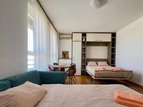 Cozy Apartment SOFI in Belville في Novi Beograd: غرفة بسريرين وسرير ومكتب