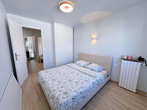 Dormitorio blanco con cama y pasillo en 5 minutes metro free parking 2 bedrooms 4-6P Near Paris, en Malakoff