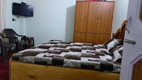 1 dormitorio con 1 cama y armario de madera en room in manali, en Manali